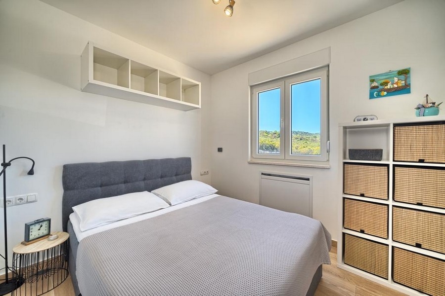 Ljust sovrum med dubbelsäng och hyllor