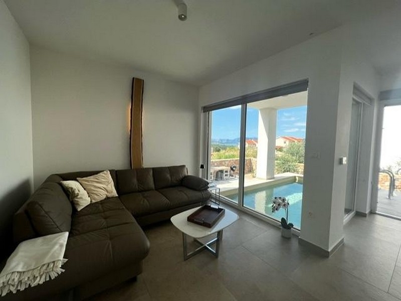 Vardagsrum med soffa och utsikt över poolen i fastighet A3723, ön Krk