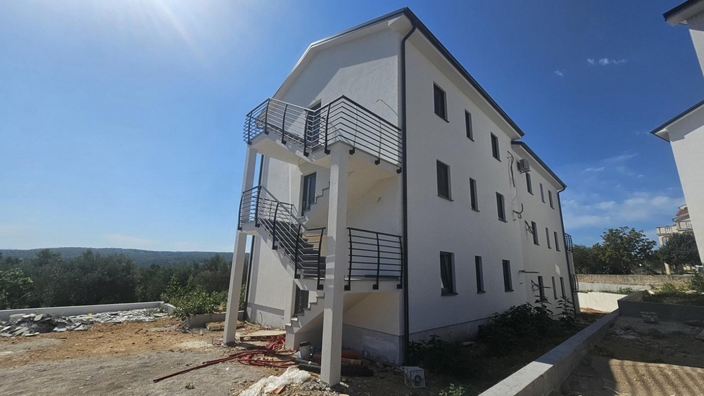 Baksida av ny byggnad med yttre trappor och omgivningar i Soline