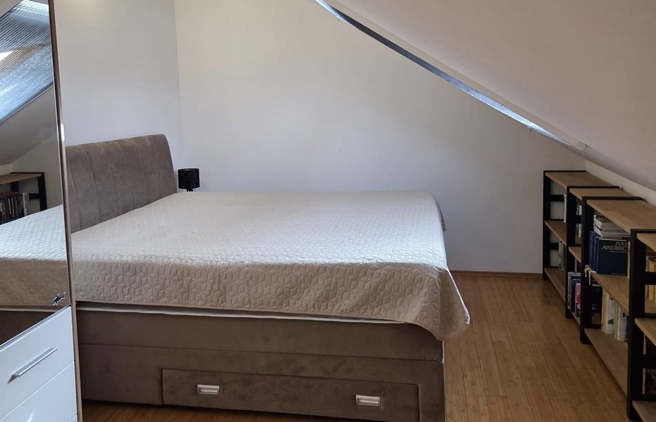 Sovrum med dubbelsäng under snedtak