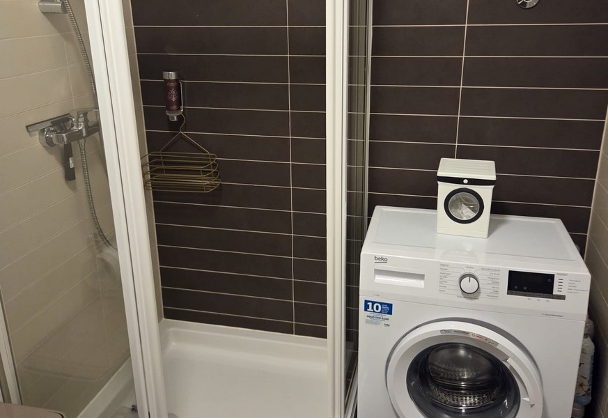 Badrum med dusch och tvättmaskin