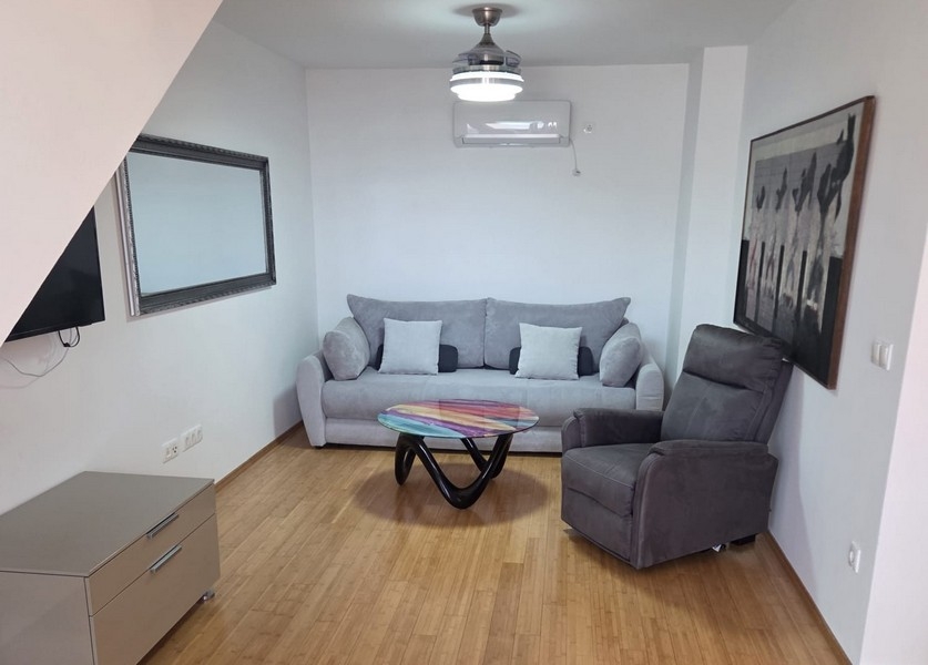 Vardagsrum med soffa, fåtölj och modernt soffbord