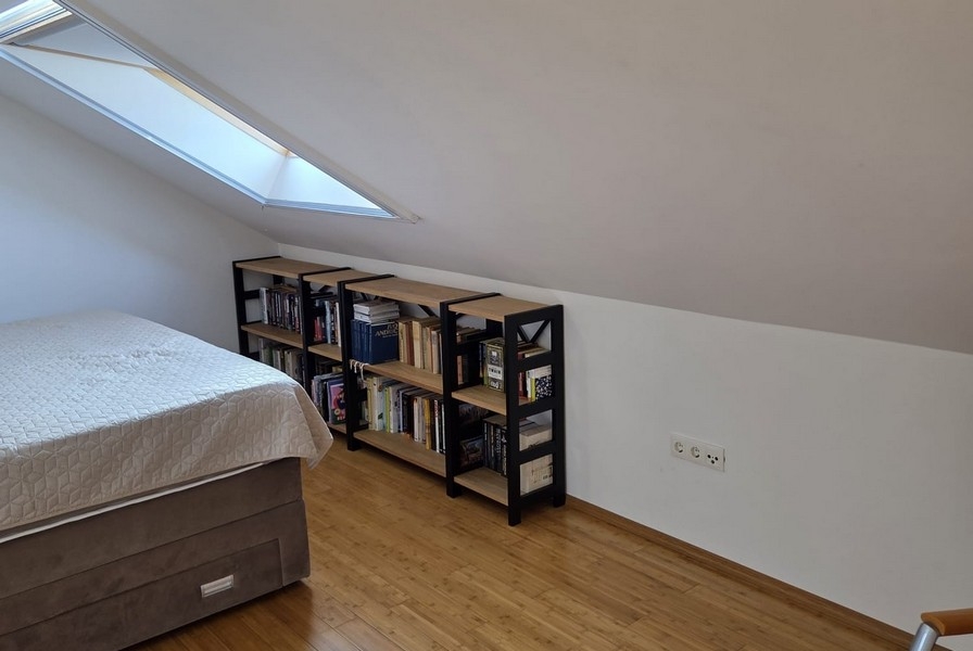 Sovrum med snedtak och bokhyllor
