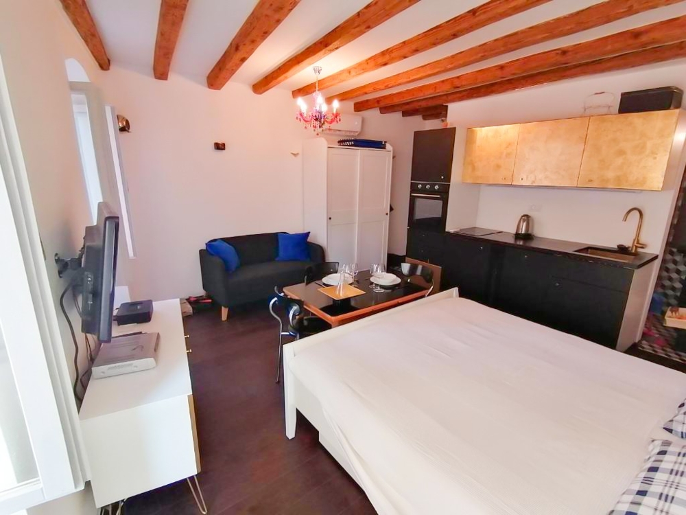 Vardagsrum med säng och kök.