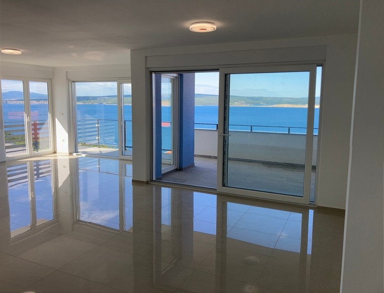 Vardagsrum med stora fönster och havsutsikt