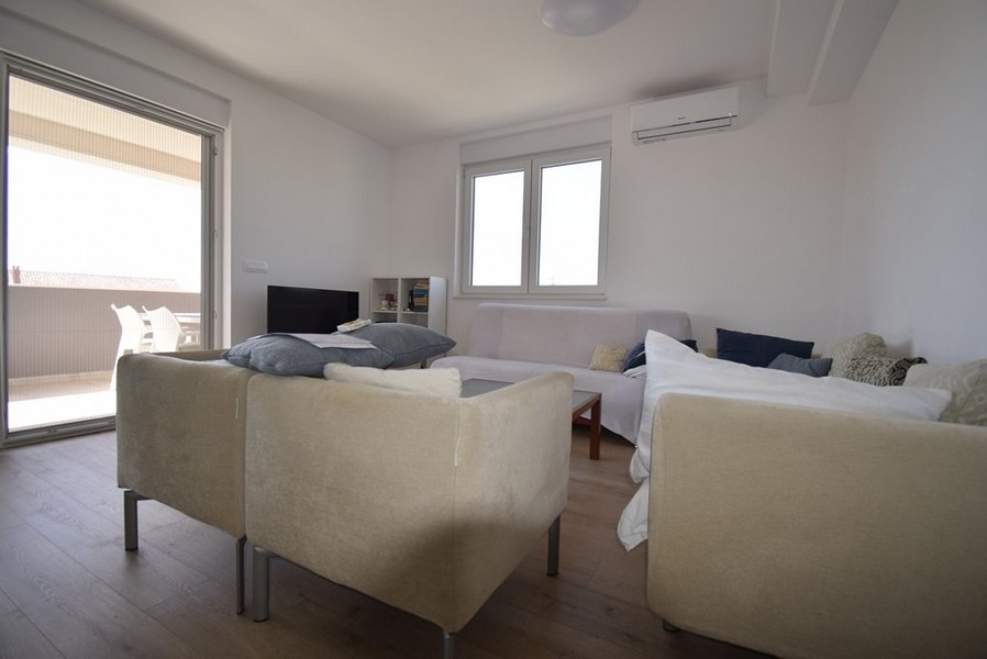 Ljust vardagsrum med soffa och utgång till altan