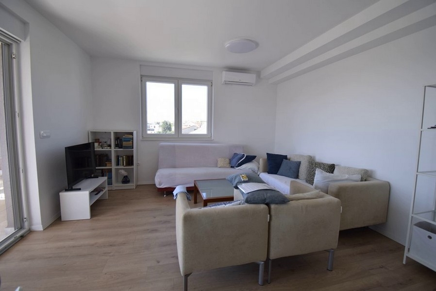 Vardagsrum med sittgrupp, TV och fönsterfront