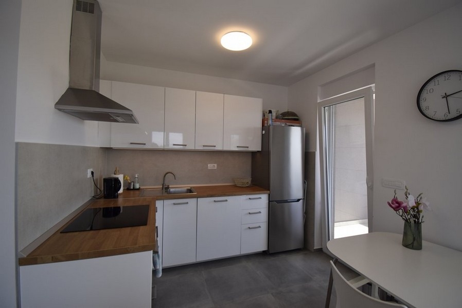 Modernt kök med inbyggda vitvaror och matbord