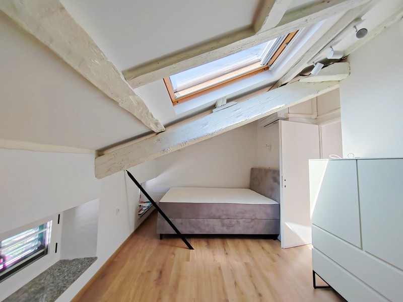 Andra sovrummet på vinden med säng och takbjälkar