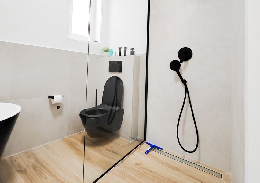 Badrum med svart toalett.