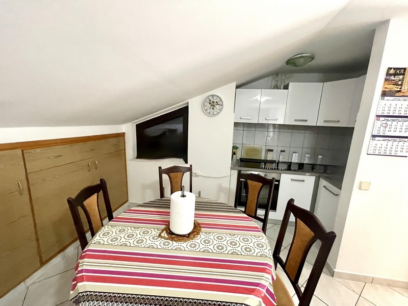 Matplats med bord och stolar bredvid köket