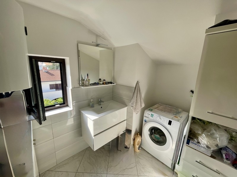 Badrum med tvättmaskin och fönster