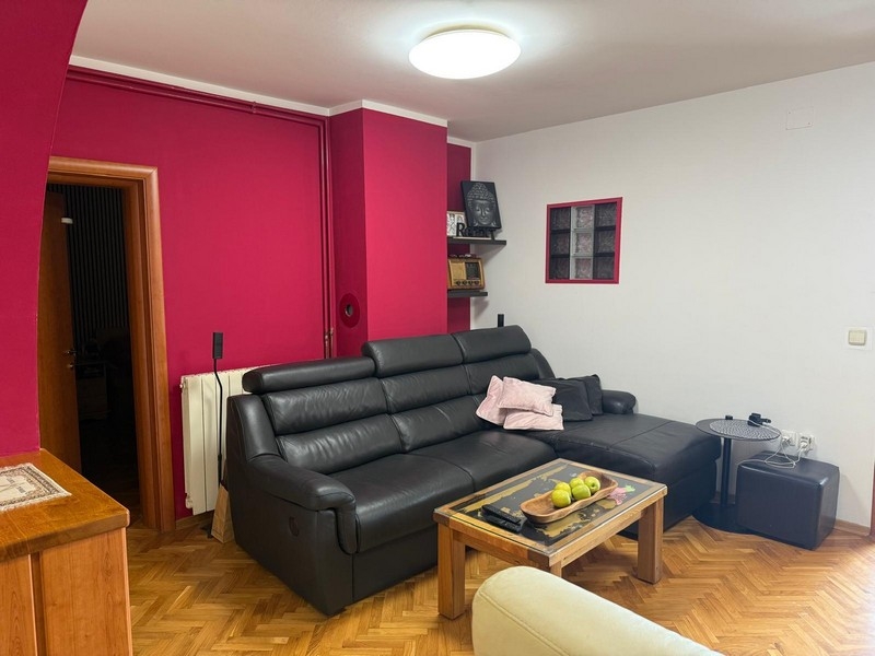 Vardagsrum med svart skinnsoffa och soffbord