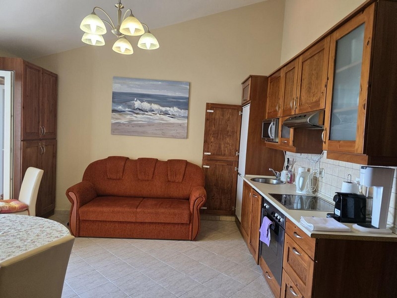 Kök med matplats och soffa i vindslägenhet