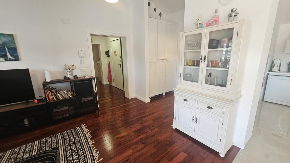 Ljust vardagsrum med vitrinskåp och tv-möbel