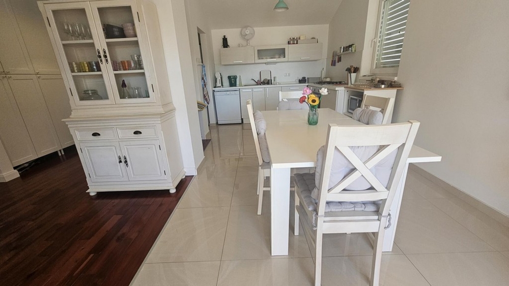 Matplats med bord och stolar bredvid köket