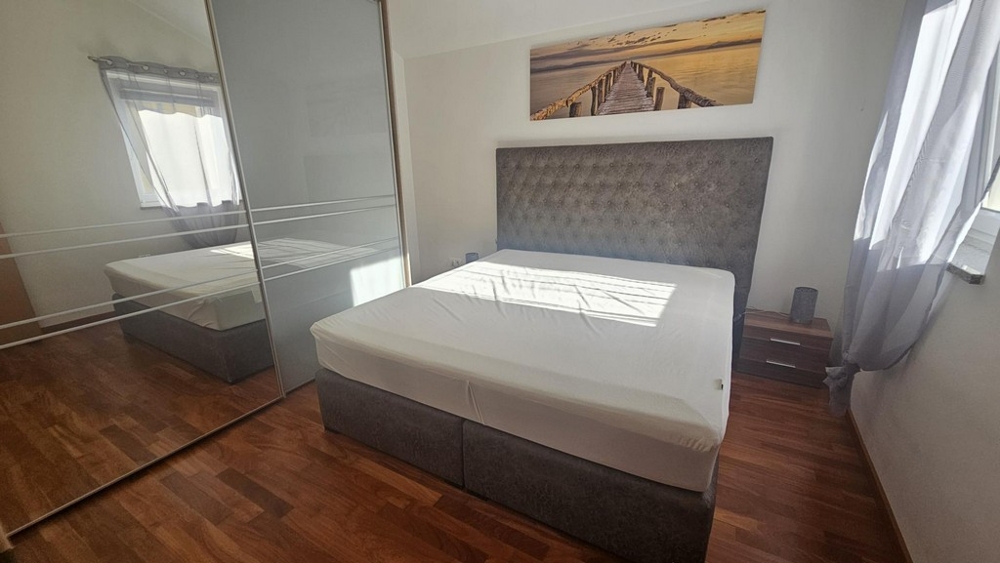 Sovrum med dubbelsäng och stort spegelskåp