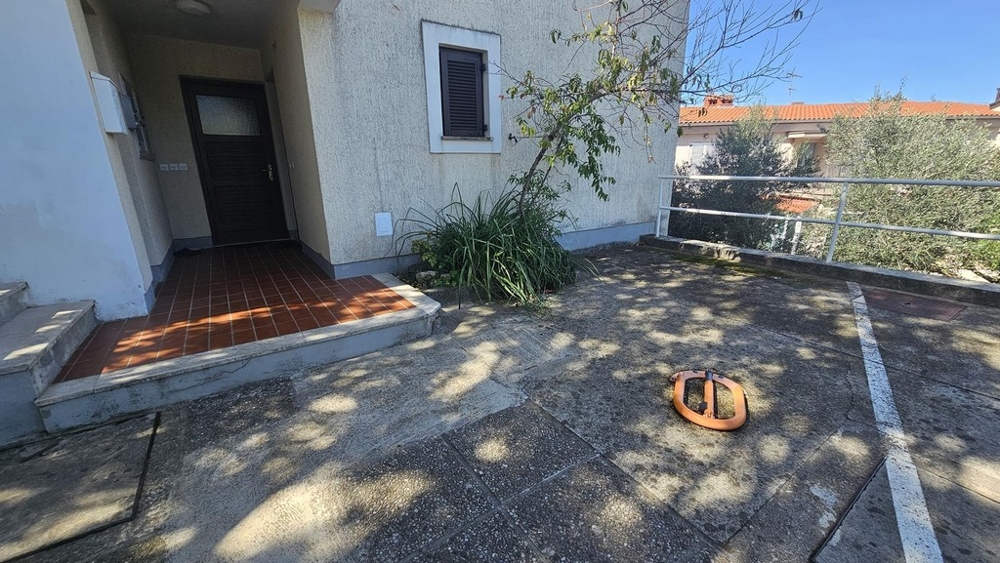 Husentré med parkeringsplats framför byggnaden