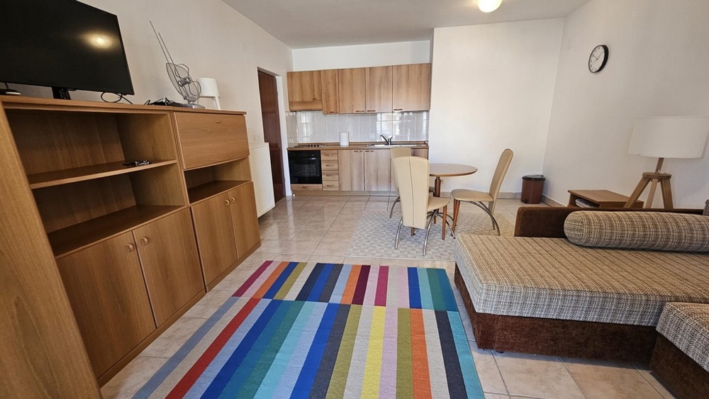 Vardagsrum med kök, matbord och soffa