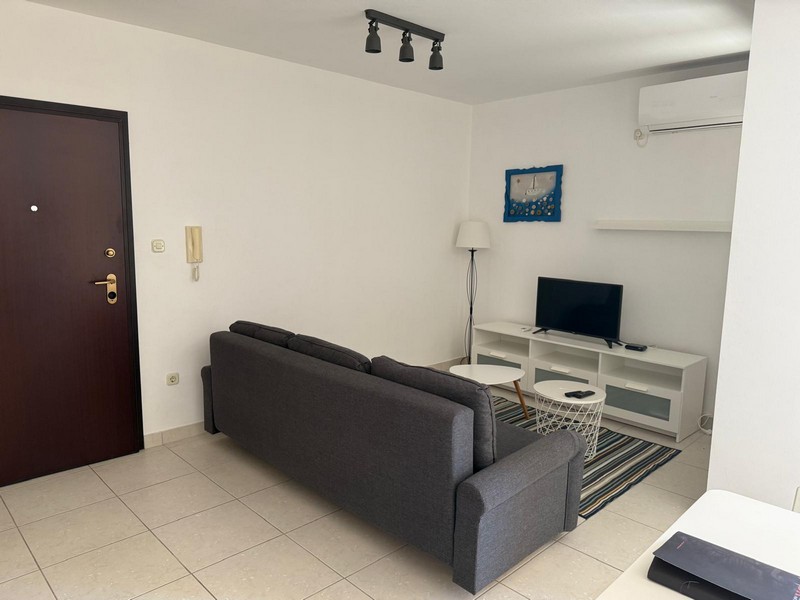 Vardagsrum med soffa och TV-möbel