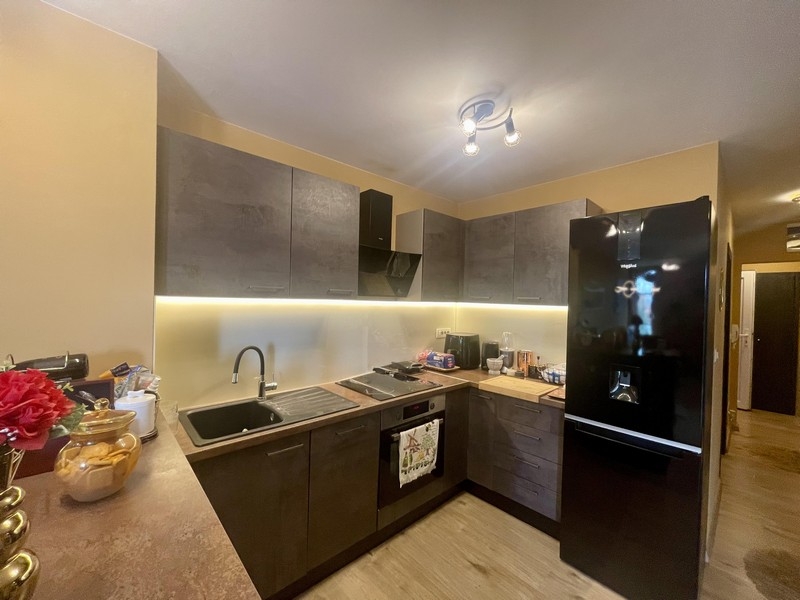 Modernt utrustat kök med mörka fronter och stort kylskåp