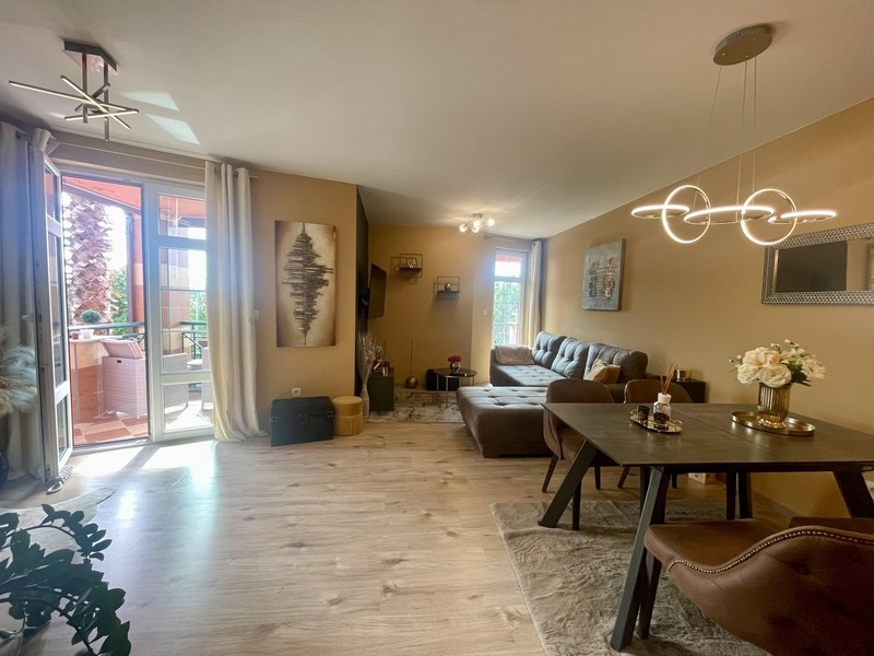 Ljust vardagsrum med matplats, soffa och utgång till terrassen