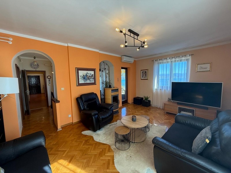 Vardagsrum med svart skinnsoffa och TV