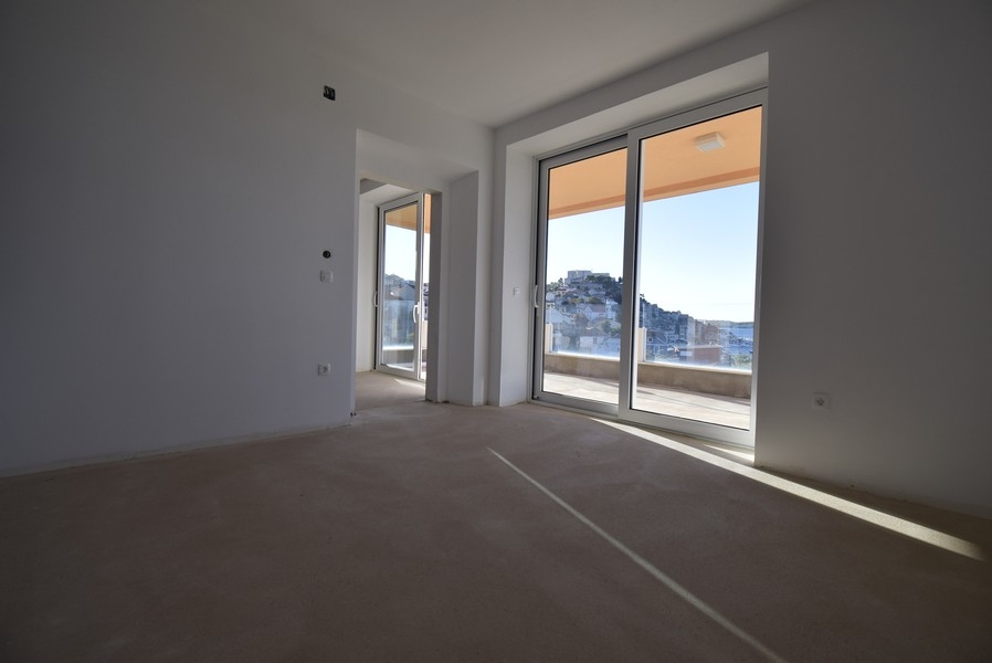 Ljust rum med stora fönsterpartier och utgång till balkong