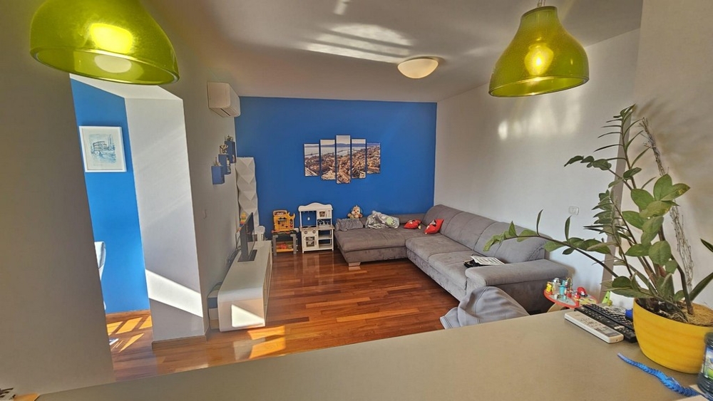 Ljust vardagsrum med öppet kök och utsikt över havshorisonten