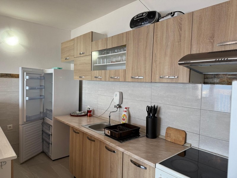 Modernt kök med träfronter och kaklad bakvägg