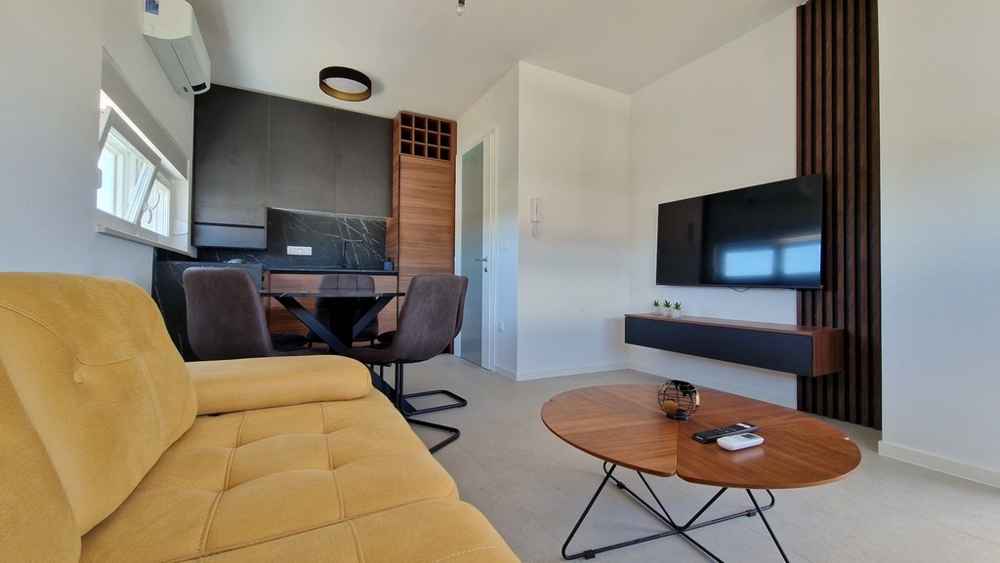 Ljust vardagsrum med TV och modern inredning