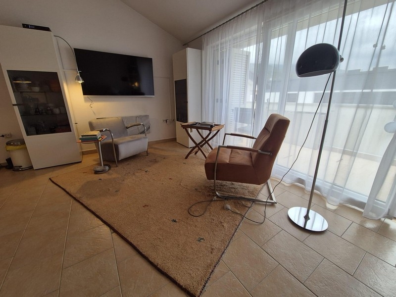 Vardagsrum med TV och utgång till altan