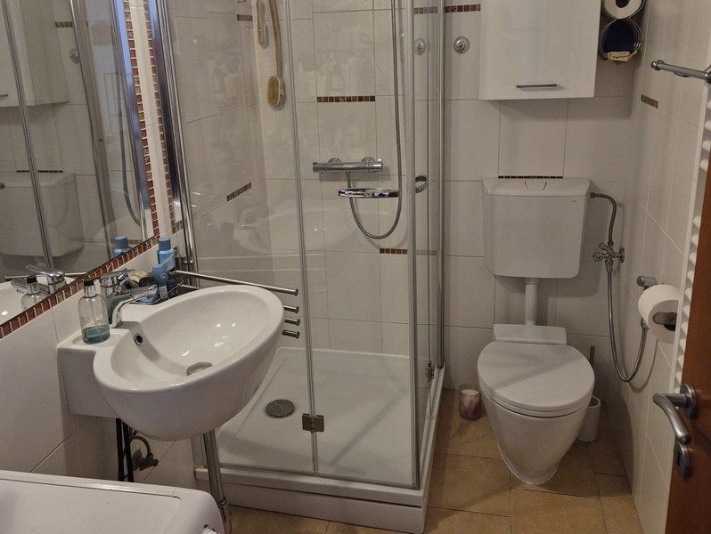 Badrum med dusch och tvättmaskin