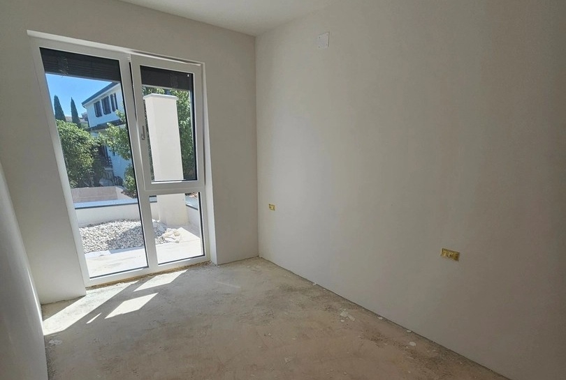 Ytterligare ett sovrum med fönster från golv till tak och utsikt över trädgården