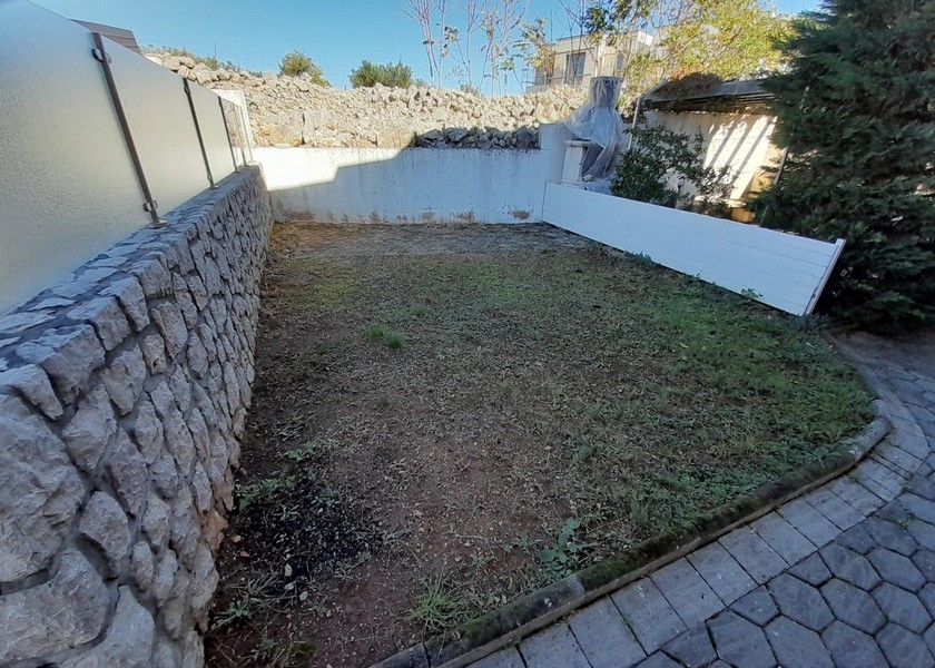 Liten trädgård med stenmur och gräsmatta