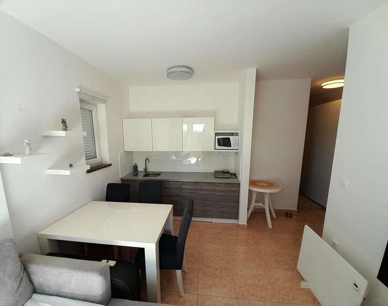 Ljust vardagsrum och köksdel med klinkergolv och tillgång till hall