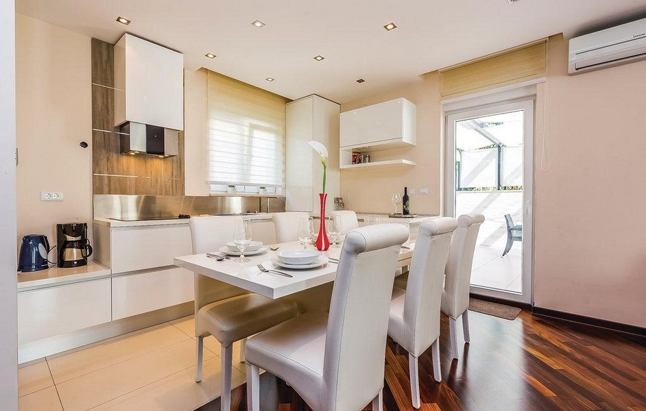 Modernt kök med matplats och utgång till altan