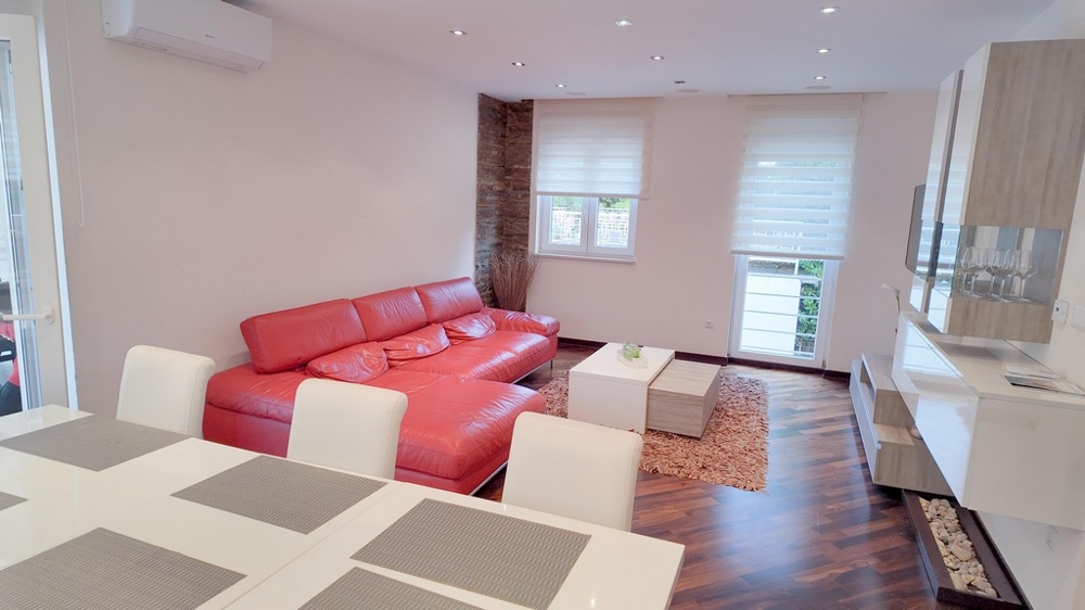 Vardagsrum med röd skinnsoffa och stilren design