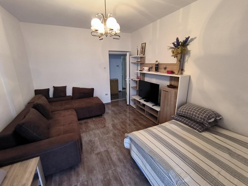 Vardagsrum med TV och sovplats