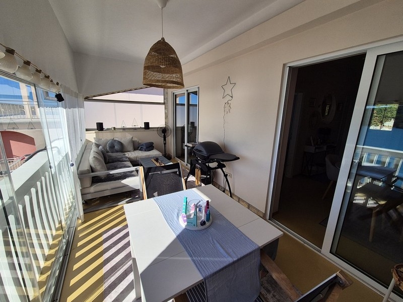 Inglasad terrass med sittgrupp och havsutsikt