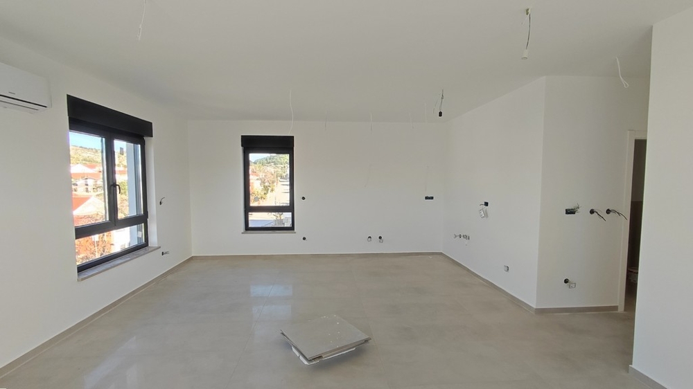 Ljust vardagsrum i ny lägenhet med stora fönsterfronter