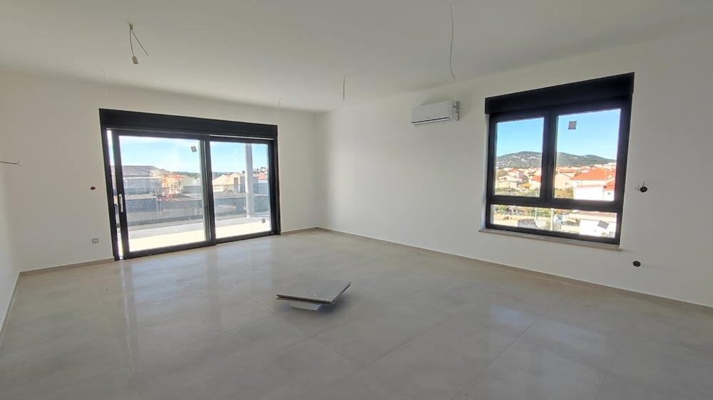 Vardagsrum med två fönster och förberedelse för kök