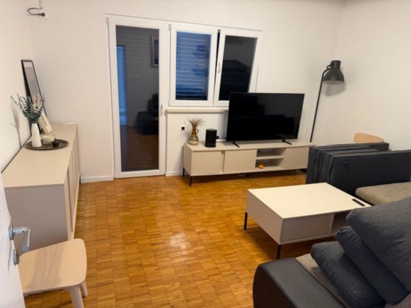 Vardagsrum med TV och utgång till altan