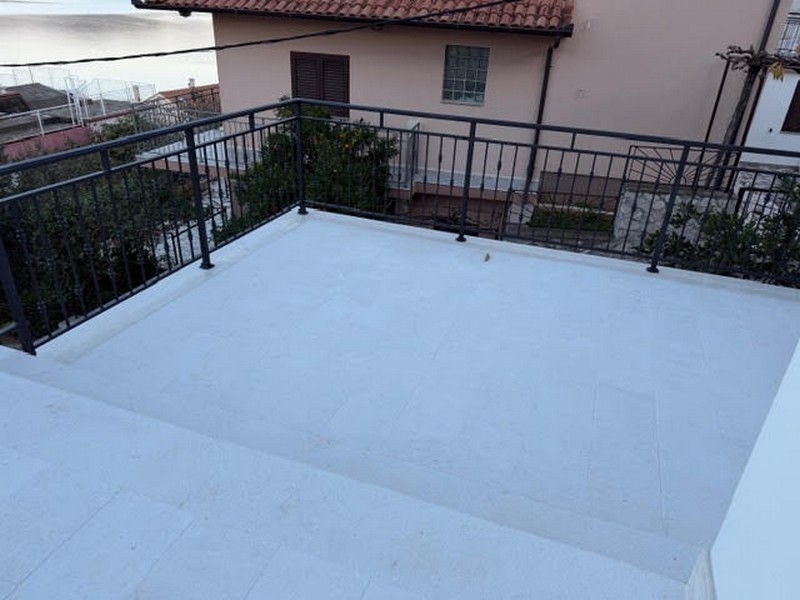 Terrassområde med räcke och utsikt över grannhuset