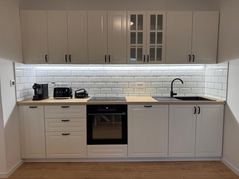 Ljust kök med vit inbyggd möbel