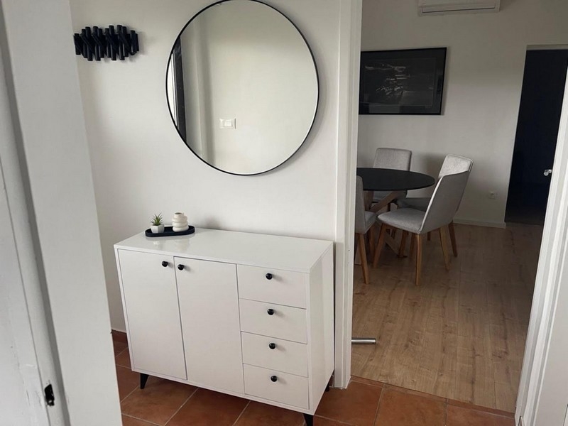 Hall med vit skänk och spegel