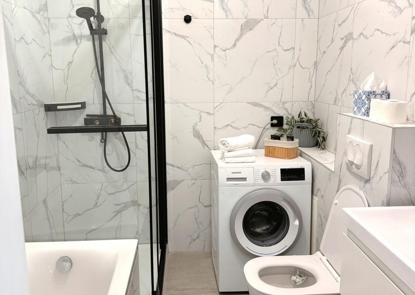 Modernt badrum med dusch och tvättmaskin