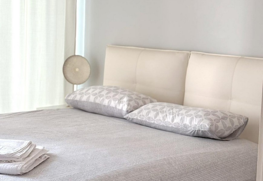 Dubbelsäng med ljusa kuddar i sovrummet på fastighet A3823 i Zadar