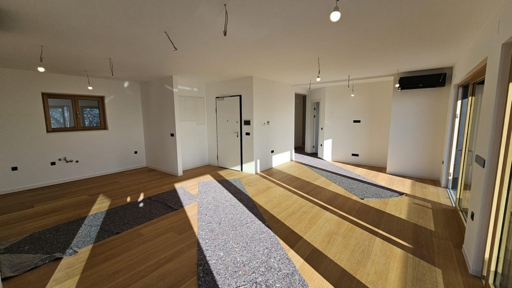 Öppet vardagsrum med fönster och tillgång till terrass