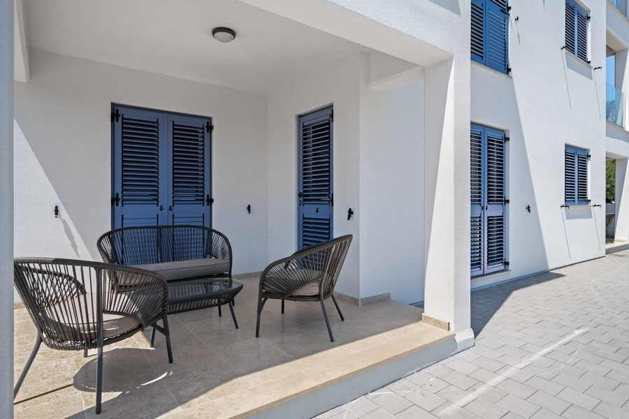 Täckt terrass med sittplatser och fönsterluckor